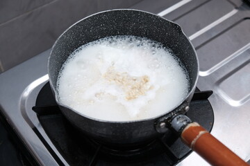 Close up of instant noodles cooking in boiling water over a stove on an open fire, Cooking instant noodles at home.