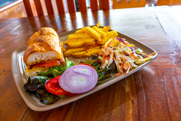 Salmon baguette sandwich with salad and French fries in Thailand.