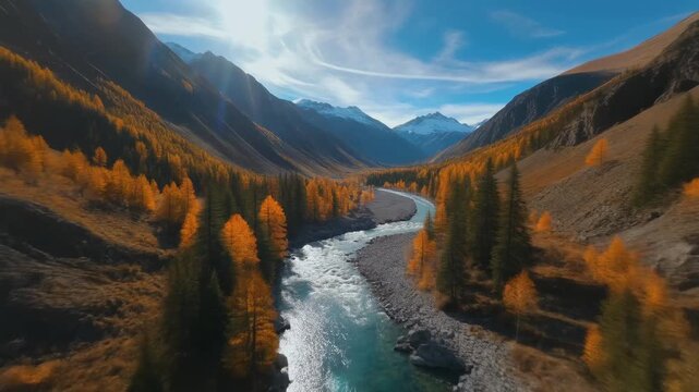 Majestic autumn mountain valley aerial view serene river flowing through golden larch forest snow capped peaks dramatic sky sun rays