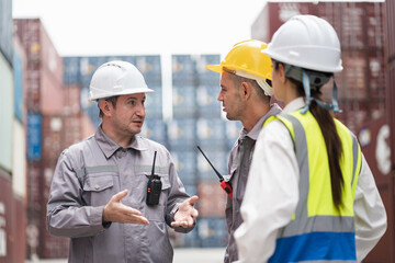 Engineer and worker team working in logistic terminal of container cargo, Diverse construction team in safety gear outdoors