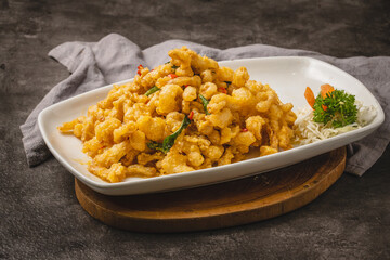 Crispy fried calamari or seafood dish with salted egg yolk coating served on a white plate.