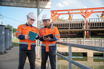 Industrial engineering team evaluating equipment conditions and discussing project tasks near the...