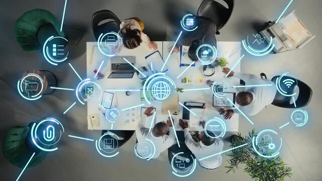 Employees in office streamlining workflow using online apps, futuristic HUD icons symbolizing digital ecosystem. Aerial view of workers using internet enterprise solutions driving business growth