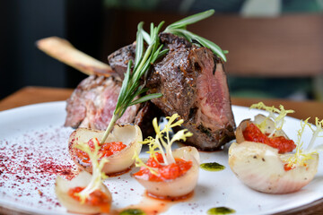 beef steak on a plate with sauce and rosemary leaves macro photo