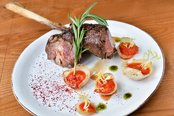 beef steak on a plate with sauce and rosemary leaves
