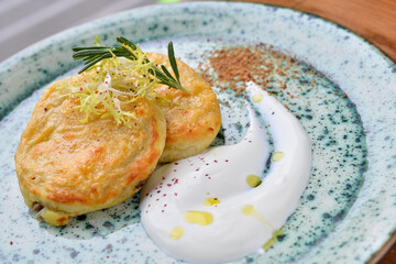 potato pancakes with sour cream in a plate macro photo
