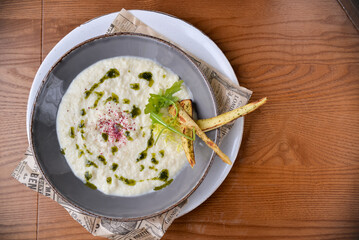 mushroom cream soup with pesto sauce and grissini in a plate