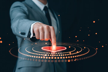 Businessman in grey suit finger touching virtual red heart icon surrounded by glowing dots technology and emotion