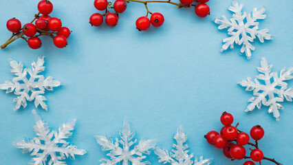 Red Berries and White Snowflakes Border on Light Blue Background