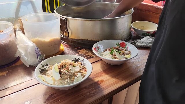 Soto Soup Stirring: Crafting Flavorful Street Food in Action. Authentic Soto Soup Preparation: Stirring Delicious Broth. Street Vendor Stirring Hot Soto Soup for a Fresh Serving