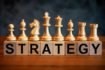 Wooden chess pieces arranged on blocks spelling out strategy, symbolizing strategic planning and competitive thinking
