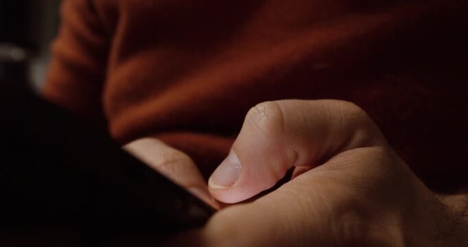 Close-up shot of a person typing on a smartphone, capturing focused hand movements and modern digital communication.