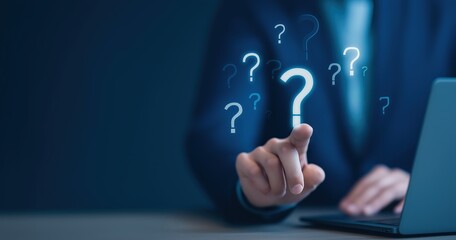 Businessman using laptop with question marks seeking answers solutions information and support for business decisions and problem solving online