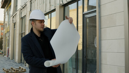 Two engineers or architects discussing plans on a construction site outdoors