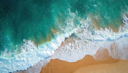 Obraz premium Aerial view of sea and beach. Blue turquoise water washes over golden sand. Waves crash with white foam creating natural patterns. Calm ocean shore invites relaxation and travel.