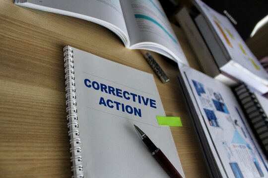 Corrective Action paperwork documentations on a desk with reports. Audit word on working paper with pen, measuring tape and calculator. Business, Finance, Audit and Budget improvement concept.