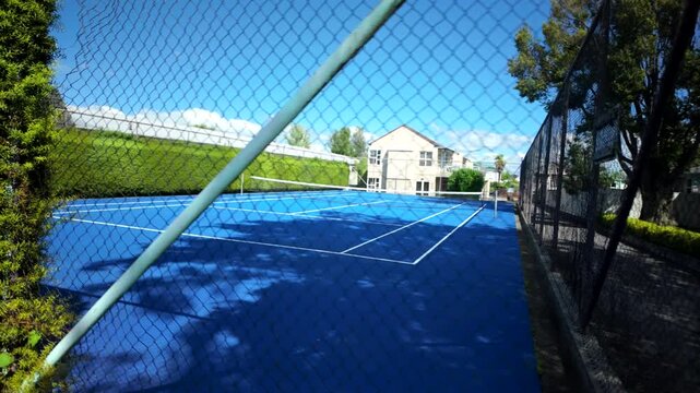 Blue Outdoor Tennis Court Beside Sidewalk And Parking Lot