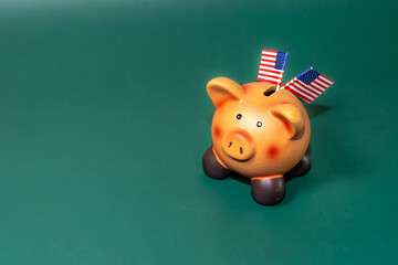 A ceramic piggy bank with American flags on a green background symbolizes savings or financial investments.