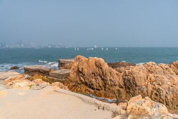 Sailing small boats and rocky shores of the Yellow sea in Qingdao, China