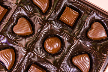 Heap of chocolate candies in a brown box. Top view
