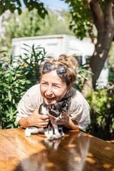 Fotobehang Ridders middle-aged woman holds a small black and white cat in her arms  © Cavan