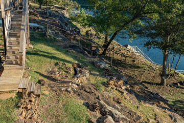 boy walking on rocky up hillside to wooden stairs
