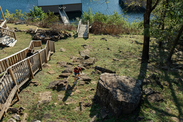 two boys walking around rocky hillside and wooden stairs
