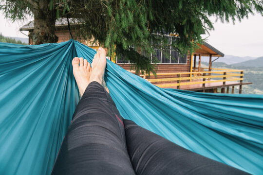 A person relaxing in a blue hammock