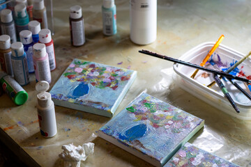 Floral canvases and painting tools on an artist’s workspace