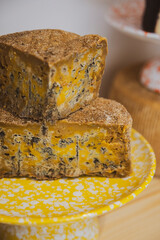 Stacks of yellow, blue cheese on yellow plate