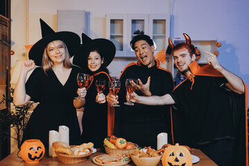 Friends enjoying a Halloween party at a bar making a toast