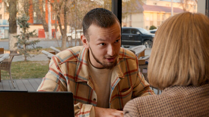 Happy couple or friends discussing ideas in a relaxed setting with notebooks