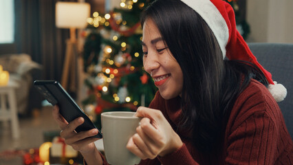 Positive Asia female wear red sweater new normal celebrate christmas smell aromatic coffee cup sit...