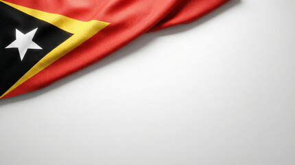 A close-up of a flag featuring red, black, and yellow colors with a white star, displayed against a neutral background.
