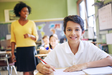 Portrait, happy boy and student in classroom with pencil for knowledge, education and assignment. Confident, child and smile in school with notebook for workbook activity, assessment and curriculum.