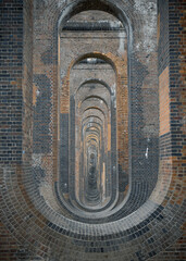 The semi-circular arches vaulting supporting traditional red brick piers with smooth limestone of Architectural splendour of Ouse Valley Viaduct or Balcombe Viaduct (Railway viaduct) has been describe