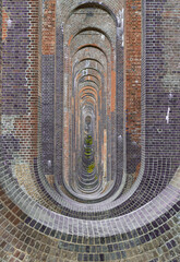 The semi-circular arches vaulting supporting traditional red brick piers with smooth limestone of Architectural splendour of Ouse Valley Viaduct or Balcombe Viaduct (Railway viaduct) has been describe