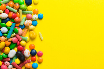 Obraz premium Mixed collection of colorful candy, on colored background. Flat lay, top view. frame of colorful chocolate coated candy