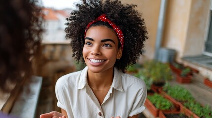 Woman smiling at camera, standing outside greenhouse, wearing headband and sunglasses.