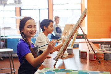 Portrait, painting and girl with smile for art class, creativity support or fine motor skill development. Education, artistic learning and happy students with canvas for lesson, paint brush and child