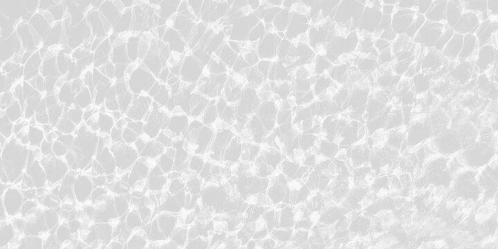 Bright sun glare on rippling, clear water over  light gray tiled surface, creating sparkling, wavy caustic pattern