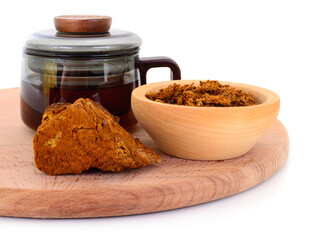 Chaga mushroom tea in glass mug with pieces on cutting board