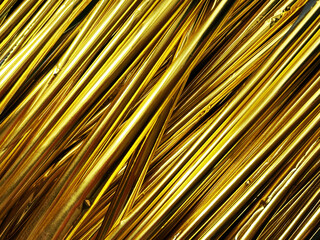Shiny golden foil strands create a reflective, metallic abstract background