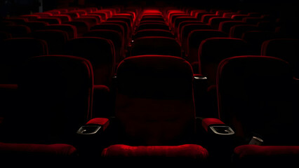 a dimly lit cinema theater showcasing rows of plush, red velvet seats