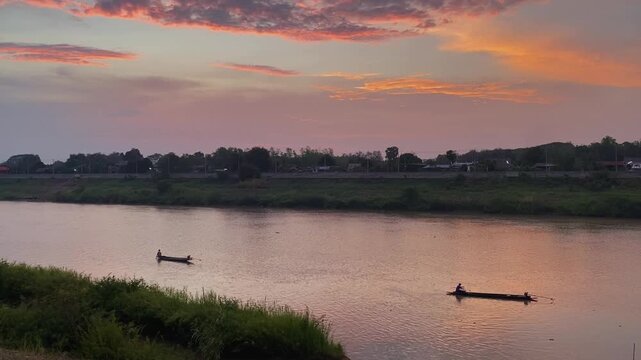 wellness concept with man sit on boat and working by catch fish in river summer evening