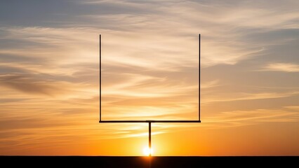 American football goalposts against a dramatic sunset sky