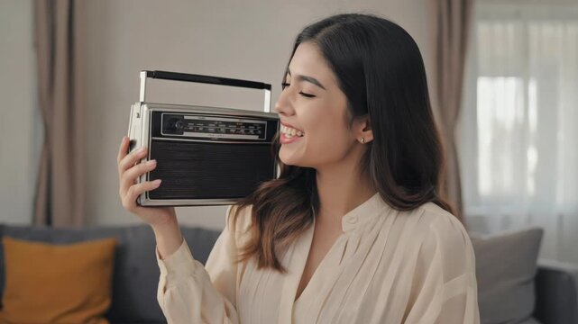 A joyful person enjoying music from an old school transistor radio.