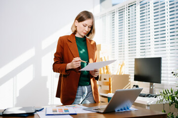 Designer selecting color palette while working on a creative branding project in a modern bright workspace.