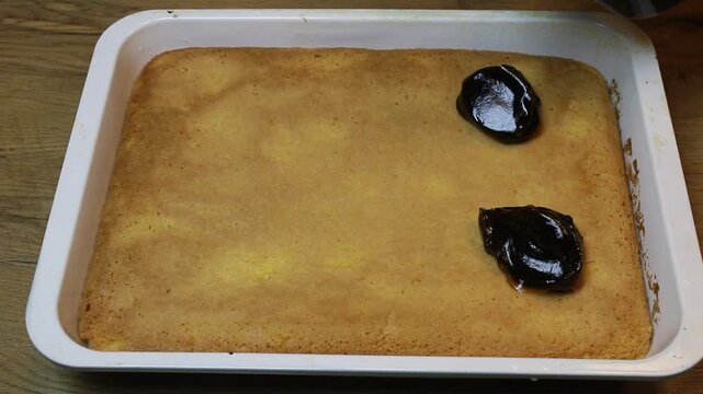 adding caramel with a spoon for Tres leches cake, pan tres leches, a sponge cake soaked in three kinds of milk, evaporated, condensed and whole milk
