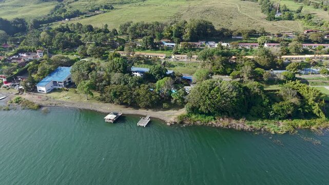 Discover Lago Calima's tranquil shoreline in this aerial footage. Lush greenery meets serene blue waters, offering a picturesque view of Colombia&rsquo;s vibrant landscape. Ideal for nature lovers.